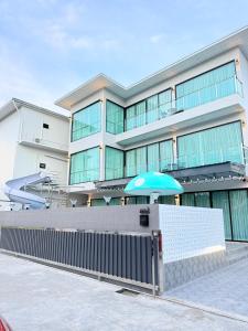 a large building with a blue umbrella in front of it at The Ocean Pool Villa HuaHin in Hua Hin
