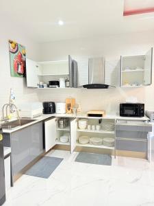 a kitchen with white cabinets and white appliances at The Ocean Pool Villa HuaHin in Hua Hin