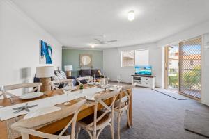 a dining room and living room with a table and chairs at Sandcastles On Currumbin Beachfront, Gold Coast in Gold Coast