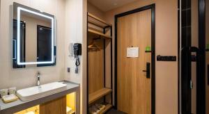 a bathroom with a sink and a mirror and a door at Green Tree Inn Shenyang Middle Street in Shenyang +61 photos