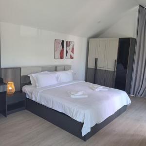 a bedroom with a large bed with two towels on it at Seashell Family-222普吉岛木屋走几步到邦涛海滩看日落周边餐饮方便 in Bang Tao Beach
