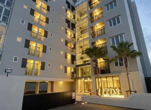 バンコクにあるUTD8 Hotel and Residenceのヤシの木が前に生えている高い建物