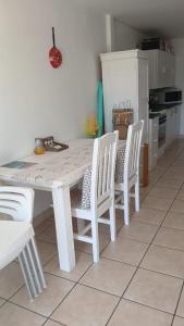 une table blanche et des chaises dans une cuisine dans l'établissement Mossel Bay Self-Catering, à Mossel Bay