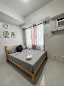 a bedroom with a bed with two white shoes on it at Casa Mira Mandaue unit 608 Tower 4 in Cebu City