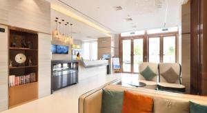 a living room with a couch and some chairs at City Comfort Inn Wuhan Hankou Bei Light Rail Station in Wuhan