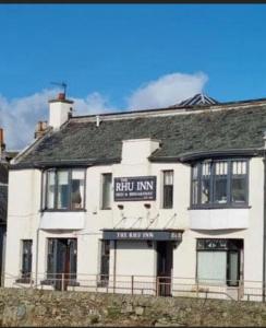 een wit gebouw met een nub inn-bord erop bij The Rhu Inn in Rhu