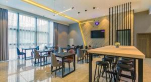 a restaurant with tables and chairs in a room at 7 Days Premium Hotel Chongqing Jiangbei International Airport Terminal 3 in Chongqing