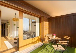 a room with a patio with a table and chairs at Vue imprenable sur les Alpes et Parking privé gratuit in Crans-Montana +7 photos