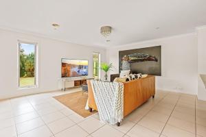 a living room with a couch and a tv at StayAU Modern Sanctuary Mins from the Ct & Airport in Point Cook