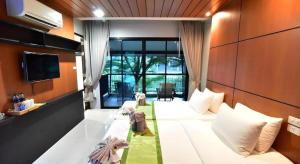 a bedroom with a large white bed and a tv at The Breeze Lipe Resort in Ko Lipe