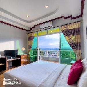 a bedroom with a bed and a large window at Breeze Hill Resort in Campson