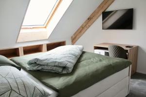 a bedroom with a bed and a desk with a television at Fuchs at home in Kaltbrunn