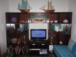 a room with a tv and a shelf with a boat on it at Dar Yanis in Rabat