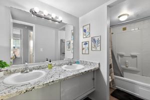 a bathroom with two sinks and a large mirror at Game Day Ready Steps to Big House, U-M Campus & UM Hospital in Ann Arbor +17 photos