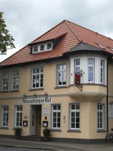 ein großes, braunes Gebäude mit rotem Dach in der Unterkunft Hotel Neuenburger Hof in Neuenburg