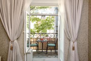 an open door with a table and chairs on a balcony at Jane Stone Apartments in Odesa