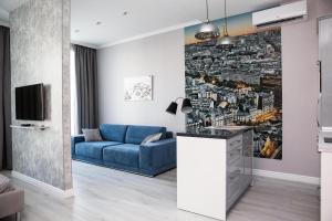 a living room with a blue couch and a wall mural at Jane Stone Apartments in Odesa