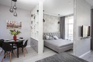 a bedroom with a bed and a table and chairs at Jane Stone Apartments in Odesa