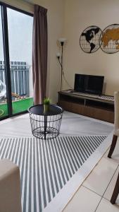 a living room with a table and a bed at MZS Studio Swiss Garden R in Kuantan