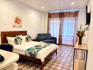 ポートビラにあるCrown Royale Hotel & Loungeのベッドと椅子と窓のある寝室