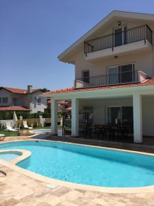 a villa with a swimming pool in front of a house at Crescent Twins -White Villa in Dalyan