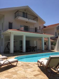 a villa with a swimming pool in front of a house at Crescent Twins -White Villa in Dalyan