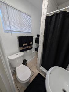 a bathroom with a toilet and a black shower curtain at Bear cave in Tucson +8 photos