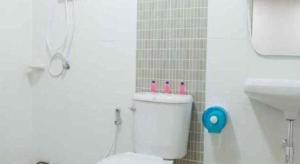 a bathroom with a white toilet and a sink at Bees Smile Hotel in Ban Fang Min