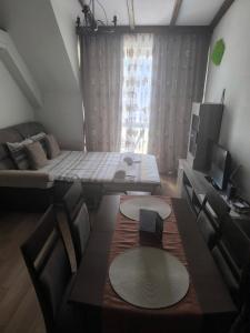 a living room with a table and chairs and a couch at студио КОМФОРТ в центъра на град Сандански in Sandanski