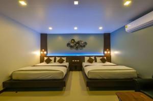 two beds in a room with a blue ceiling at Laekhong River Resort in Ban Na Muang