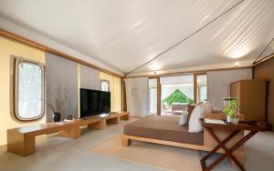 a living room with a couch and a tv at Kirimaya Golf Resort Spa - SHA Plus Certified in Mu Si