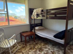 Dormitorio pequeño con litera y silla en 77 International Tourist House, en Mandurah