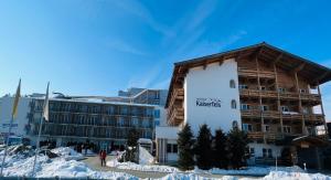 蒂罗尔州圣约翰Alpenhotel Kaiserfels的大楼前的雪地里的酒店