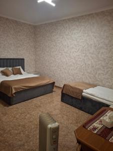 a hotel room with two beds and a table at Tatev Hotel in Tatʼev