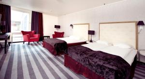 a hotel room with two beds and a desk at Home Hotel Grand Olav in Trondheim +33 photos