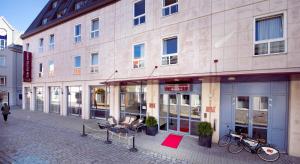 a building on a street with bikes parked in front of it at Home Hotel Grand Olav in Trondheim