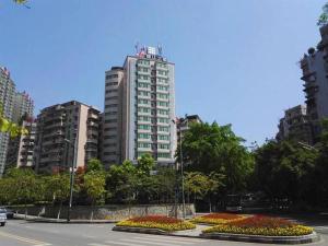 ZigongにあるJinjiang Inn Zigong Tongxing Road Branchの高いビルが立ち並ぶ街と花が咲く通り