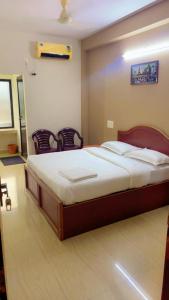 Hotel Kalyani International في Mūlki: غرفة نوم فيها سرير وكراسي