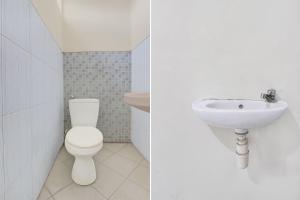 a white bathroom with a toilet and a sink at Hotel O Near Tugu Yogyakarta 2 formerly Monjali Inn in Jetis +19 photos