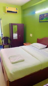 a bedroom with a large bed with green walls at Hotel Kalyani International in Mūlki