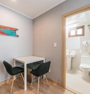 a bathroom with a table and chairs and a toilet at Stay Hyun in Jeju