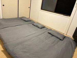 un letto con due cuscini sopra in una stanza di Village Misaki a Misaki