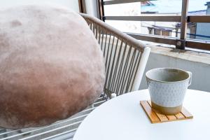 a coffee cup sitting on a table on a table at Japandi 4 Inspired 1BR in Prime City Spot and Near Station in Fukuoka