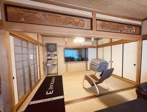 a living room with a chair and a kitchen at Village Misaki in Misaki