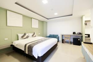 Un dormitorio con una cama grande y un escritorio. en UTD8 Hotel and Residence, en Bangkok