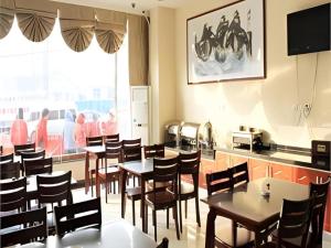 a restaurant with tables and chairs in a room at GreenTree Inn Jinan Bus Terminal in Jinan