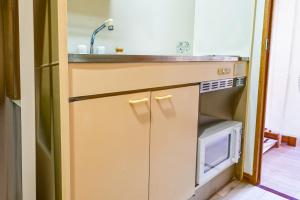 a kitchen with a sink and a microwave at Japandi 4 Inspired 1BR in Prime City Spot and Near Station in Fukuoka