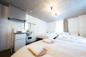 a room with two beds and a sink in it at The Book Lounge Hotel Kani in Kani