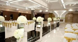 a room with white chairs and tables and flowers at Richell Hotel in Andong