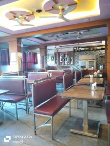 a dining room with tables and chairs in a restaurant at Hotel Kalyani International in Mūlki